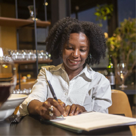 A woman writing on a piece of paper inside a restaurant